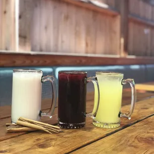  a row of three mugs on a wooden table
