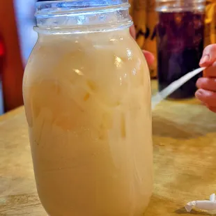 a person holding a spoon and a jar of food