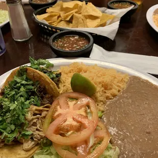 Taco plate with chips and salsa in background