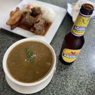 a bowl of soup and a bottle of beer