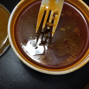 a fork in a bowl of sauce