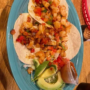 a plate of shrimp tacos and avocado