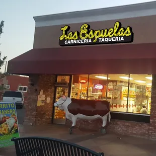a cow statue in front of the store