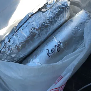 2 Asada burritos with everything one with red salsa the other green salsa