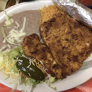 Chicken Milanesa with rice and beans, guacamole lettuce tomato and jalapeño.  DELICIOUS