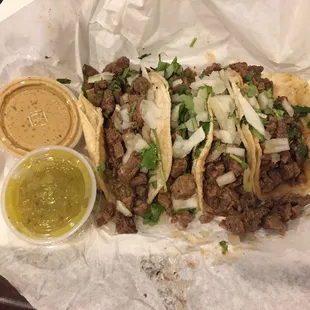 Four small carne asada tacos with green and habanero salssa