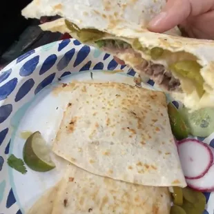 a person holding a plate of quesadillas