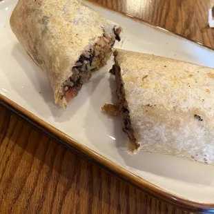 a burrito cut in half on a plate