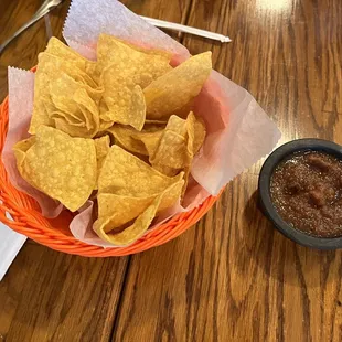 a basket of tortillas and a bowl of salsa