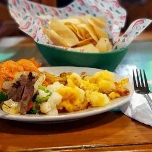 Enchiladas, potatoes  fajitas, mixed vegetables, and chips.