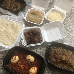 Clockwise from the top: Okra Soup, Garri, Pounded Yam, Fried Plantains, Egusi Soup, Ofada Stew, Rice