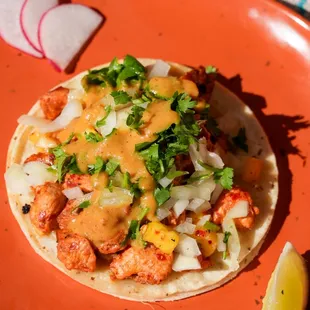 Puerco enchilado served with sweet and spicy pineapple salsa, onions, and cilantro for a perfect balance of flavors.