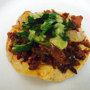 Tostaditas, cheese, Al pastor, grilled onions, avocado salsa, and cilantro