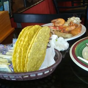 a plate of shrimp tacos and a tortilla