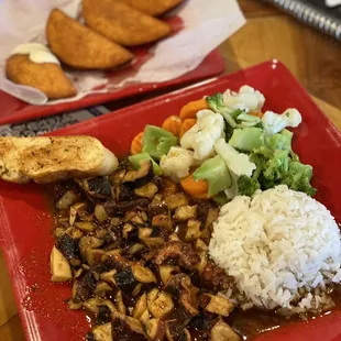 a red plate with rice, meat, and vegetables