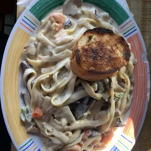 a plate of pasta with shrimp and mushrooms