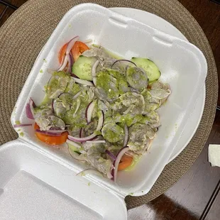 a plastic container with a salad in it