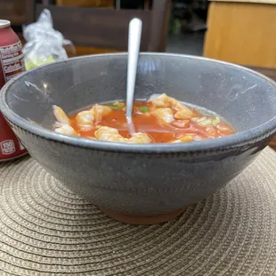 a bowl of soup and a can of soda