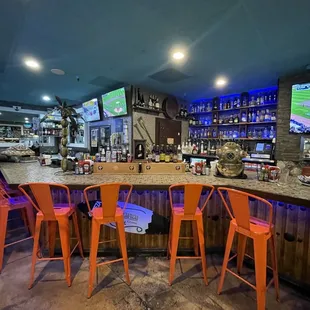 a bar with orange stools