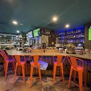 a bar with orange chairs