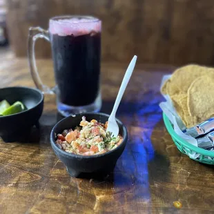 a bowl of salsa and a glass of beer