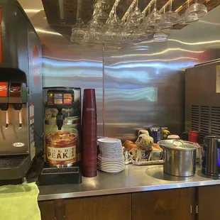  a counter with a coffee machine and a bunch of plates