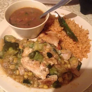 Pollo con Calabaza. Chicken and squash plate with a side of rice and beans.