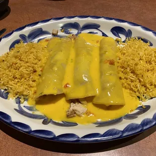 Chicken fajita enchiladas with double rice and queso added instead of gravy.