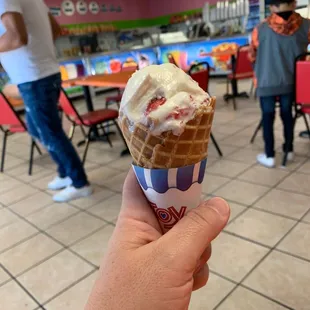 a hand holding an ice cream cone