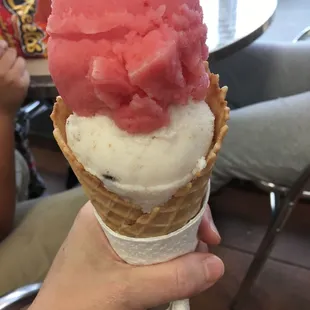 a hand holding a cone of ice cream