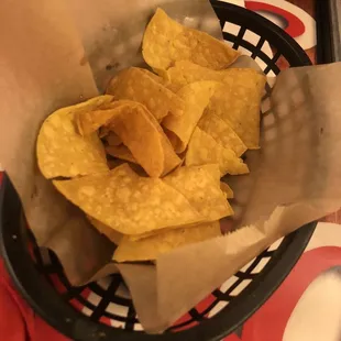 Regular Tortilla chips as appetizers that were brought to the table and they came with a spicy red dip.