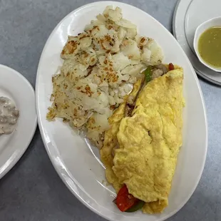 Aerial shot of chicken fajita omelette with salsa. (Partial picture of biscuits and gravy on the left.)