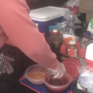 a woman preparing food in the back of a car