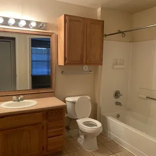 Large and spacious bathroom / tub / shower with showroom light bulbs