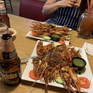 a woman sitting at a table with plates of food