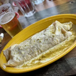 a yellow plate with a burrito on it