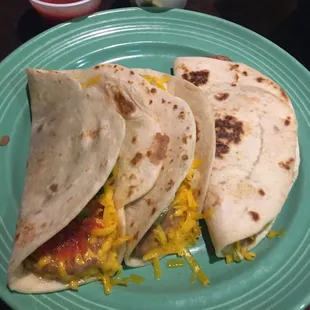 three tortillas on a green plate