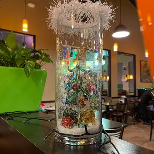 a glass filled with snow and christmas decorations