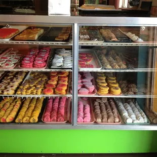 a variety of donuts in a display case