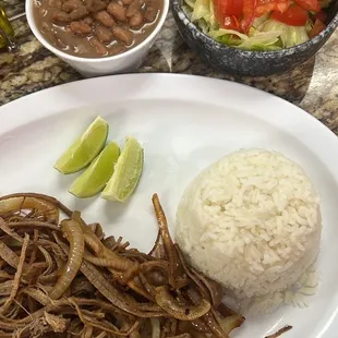 Our Vaca Frita, Grilled Shredded Flank Steak served here with White Rice, Red Beans, and a side of Salad