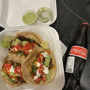 a bottle of coke and two tacos