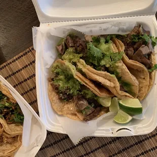 Tacos de lengua on your right with avocado green salsa, cilantro and lime.
