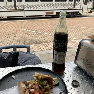 a plate of food and a bottle of soda
