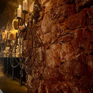 Rock fireplace with cowboy hats in the bar.