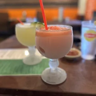 Strawberry margarita with sugar on the rim. With a margarita rocks behind.