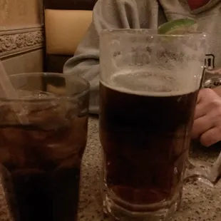 a man sitting at a table with a glass of cold beverage
