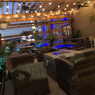 a patio with wicker furniture and lights