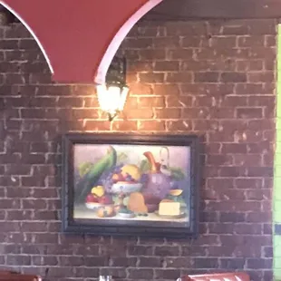 a brick wall with a painting on it