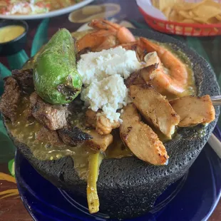 MOLCAJETE MAR Y TIERRA bountiful meal with wonderful flavor served bubbling hot