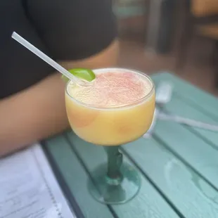 a person sitting at a table with a drink
